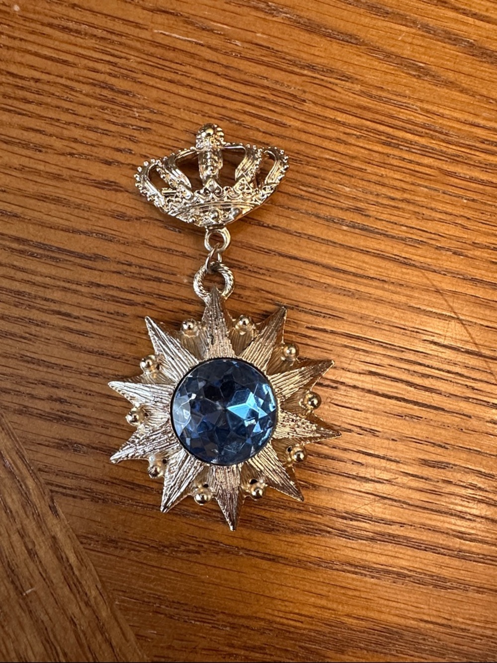 Gold-Tone Starburst Pendant with Blue Crystal